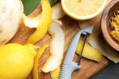 Lezzetli taze limonlar, soyucu ve siyah masa üzerinde yapraklar, düz uzanmış