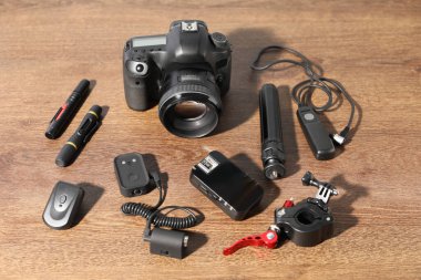 Ahşap arka planda farklı profesyonel fotoğrafçı ekipmanları var.