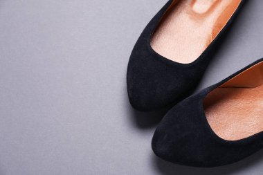 Gri arka planda bir çift şık siyah ayakkabı, düz. Metin için boşluk