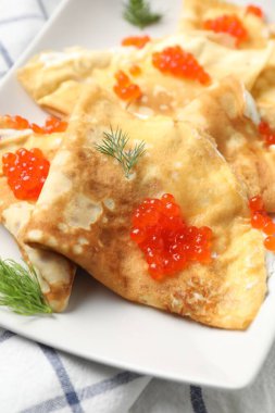 Kırmızı havyarlı ve ekşi kremalı leziz krepler, yakın plan.