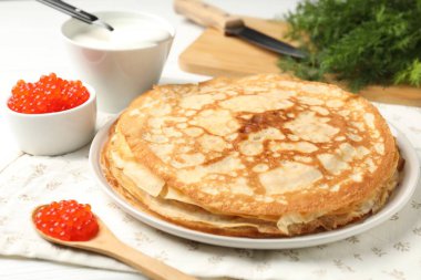 Kırmızı havyarlı lezzetli krepler, ekşi krema ve dereotlu masa, yakın plan.