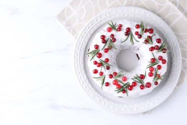 Beyaz mermer masa üzerinde kızılcıklı ve biberiyeli lezzetli Noel pastası, üst manzara. Metin için boşluk