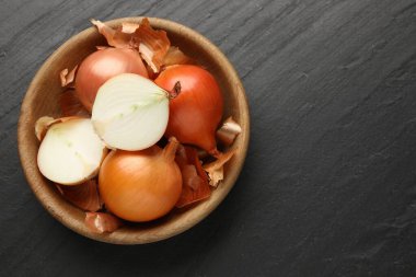 Siyah desenli masa üzerinde kabuklu soğan ampulleri, üst manzara. Metin için boşluk