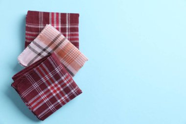 Açık mavi arka planda farklı tarz kumaş mendiller, düz yatış. Metin için boşluk