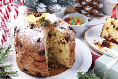 Lezzetli noel panettone pastası pudra şekeri ve beyaz masa üzerinde şenlikli dekor, yakın plan.