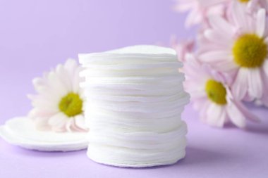 Leylak arka planında temiz pamuk pedleri ve çiçekler, yakın plan.