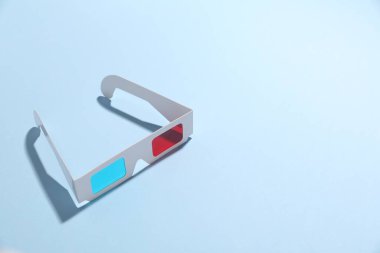 Açık mavi arka planda 3D gözlükler, yakın plan. Metin için boşluk