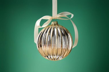 Yeşil arka planda sallanan bir Noel topu, yakın plan.