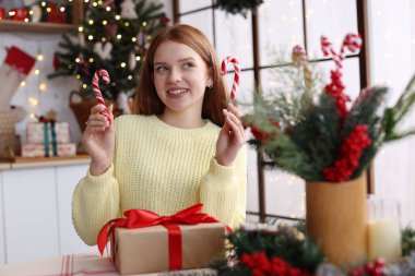 Noel için süslenmiş şeker kamışlı güzel bir genç kız.