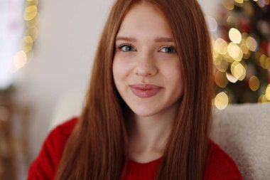 Evdeki bulanık ışıklara karşı güzel genç kız, yakın çekim. Noel atmosferi