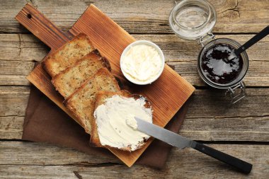 Tahta masada kızarmış ekmek, tereyağı ve reçel.
