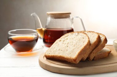 Beyaz ahşap masada çay eşliğinde ekmek dilimleri
