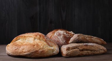 Tahta masadaki farklı ekmek türleri, yakın plan.