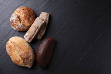 Siyah masa üzerinde farklı ekmek türleri, düz yatıyordu. Metin için boşluk
