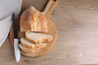 Tahta masada taze ekmek ve bıçak kes, üst manzara. Metin için boşluk