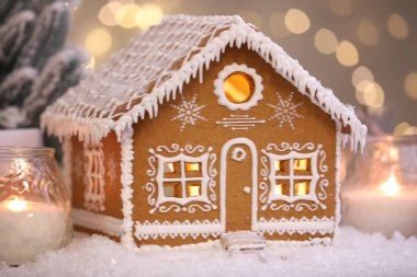 Güzel zencefilli kurabiye evi ve Noel dekoru bulanık ışıklara karşı, yakın plan