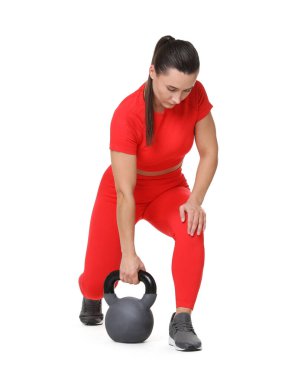 Beyaz arka planda kettlebell egzersizi yapan atletik kadın.