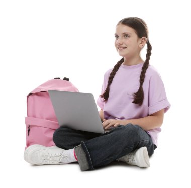 Beyaz arka planda dizüstü bilgisayarı ve sırt çantası olan tatlı bir kız.