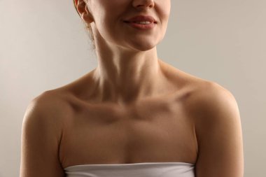 Açık gri arka planda normal ciltli kadın, yakın plan.