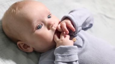 Yeni doğmuş şirin bir bebek, yatağın üstünde, manzaranın üstünde. Kamera içeri giriyor.