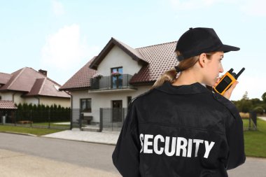 Güvenlik görevlisi evin yakınındaki telsizi kullanıyor. Özel mülk koruması