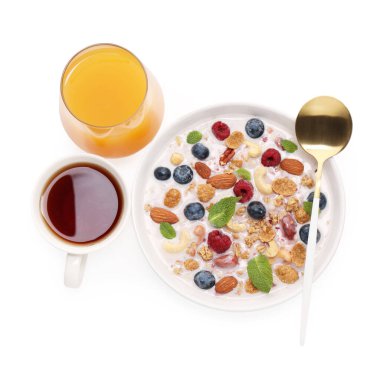 Sağlıklı kahvaltı. Fındıklı yulaf ezmesi, böğürtlen, süt kasede, çay ve meyve suyu beyaza izole edilmiş, üst manzara