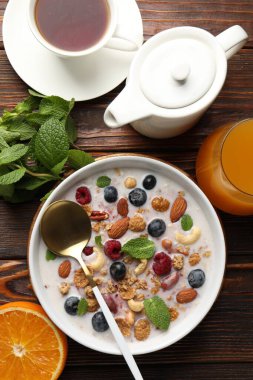 Sağlıklı kahvaltı. Fındıklı yulaf ezmesi, böğürtlen ve süt kasede ahşap masada servis edilir.