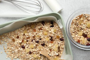 Tahıl yapıyorum. Gri desenli masada kurumuş meyveli yulaf ezmesi, düz uzanmış.