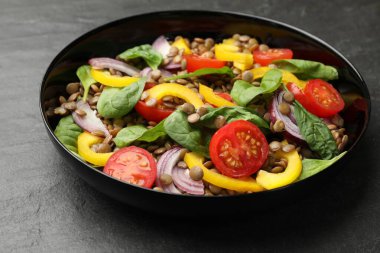 Gri desenli masada mercimek ve sebzeli lezzetli salata, yakın plan.