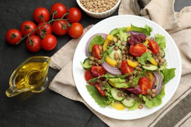 Lezzetli mercimek salatası. Gri dokuma masasında malzemeler var.