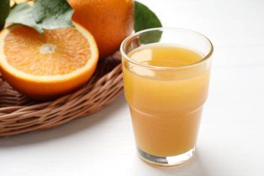 Taze portakal suyu ve beyaz masada meyveler, yakın plan.