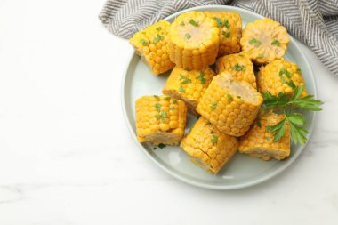 Beyaz masadaki maydanozlu mısır koçanı parçaları. Metin için boşluk