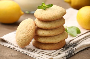 Lezzetli limonlu kurabiyeler, nane ve meyveler ahşap masada, yakın plan.