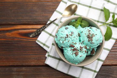 Nefis naneli çikolata parçalı dondurma, tahta masa üzerinde kaşık ve havlu, üst manzara. Metin için boşluk