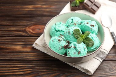 Ahşap masada sunulan yapraklı naneli çikolatalı dondurma. Metin için boşluk