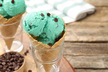 Tahta masadaki waffle külahlarında naneli çikolatalı dondurma. Metin için boşluk