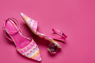 Pembe arka planda bir çift şık ayakkabı, düz yatış. Metin için boşluk