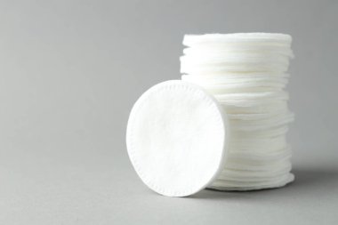 Açık gri arka planda temiz pamuk pedleri, yakın plan. Metin için boşluk