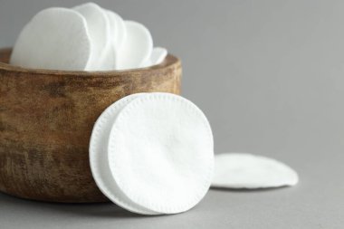 Açık gri arka planda temiz pamuk pedler, yakın plan. Metin için boşluk