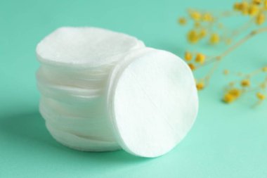 Turkuaz arka planda temiz pamuk pedleri ve çiçekler, yakın plan