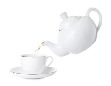 Beyaz arka planda çaydanlıktan fincana sıcak çay dökmek