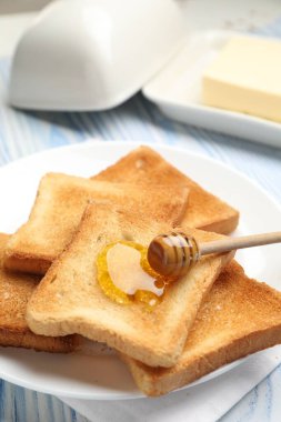 Hafif ahşap masada ballı taze kızarmış ekmek, yakın plan.