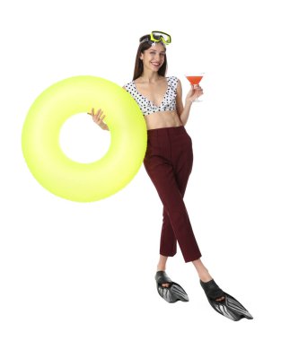 Kokteyl, dalış maskesi, paletleri ve beyaz arka planda şişme yüzüğü olan bir iş kadını.