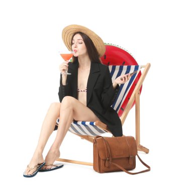 Beyaz arka planda güverte koltuğunda kokteyl ve akıllı telefonu olan bir iş kadını.