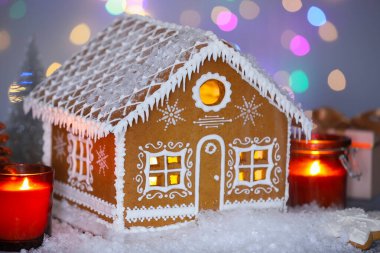 Güzel zencefilli kurabiye evi ve Noel dekoru bulanık ışıklara karşı, yakın plan