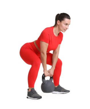 Beyaz arka planda kettlebell egzersizi yapan atletik kadın.