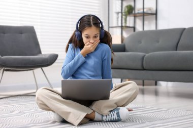 Siber tehlike. Evde dizüstü bilgisayar kullanan korkmuş bir kız.