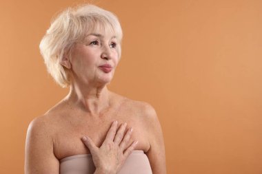 Soluk turuncu arka planda güzel bir son sınıf öğrencisi. Metin için boşluk