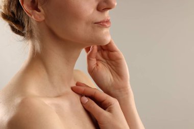 Açık gri arka planda normal cildi olan bir kadın, yakın plan. Metin için boşluk