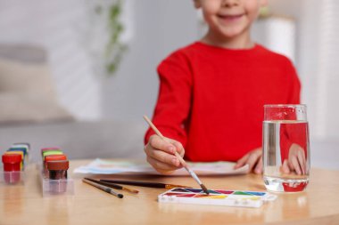 İçerideki ahşap masada resim yapan şirin bir çocuk. Metin için boşluk